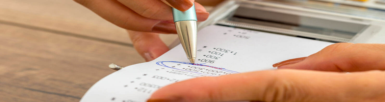 tax_audit a hand circling numbers on a piece of paper that has a group of calculations